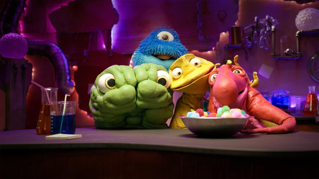 Vier Puppen vor Kulisse